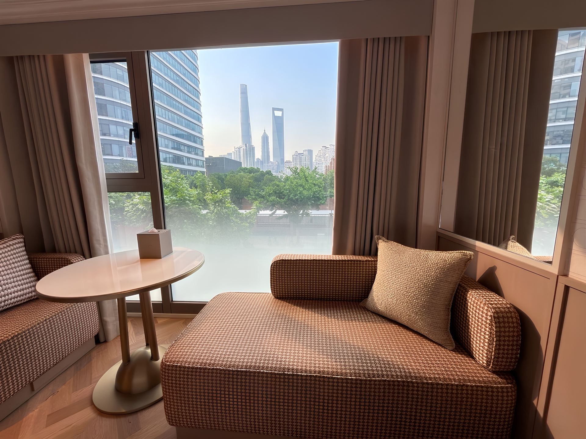 Window-side seating in a Premium King Room, looking towards Shanghai Tower, Shanghai World Financial Center and Jin Mao Tower